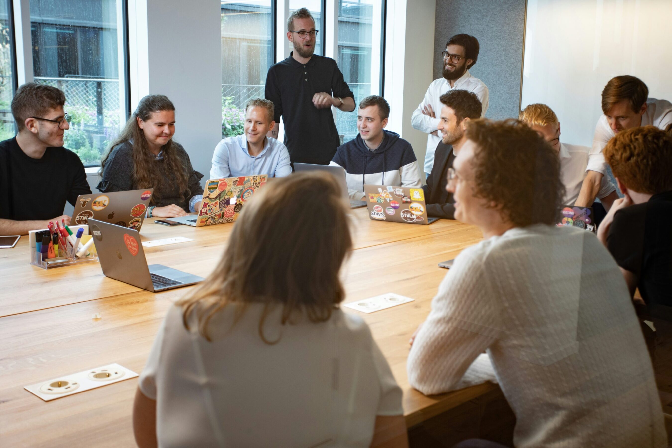 A diverse group of people sitting around a wooden table