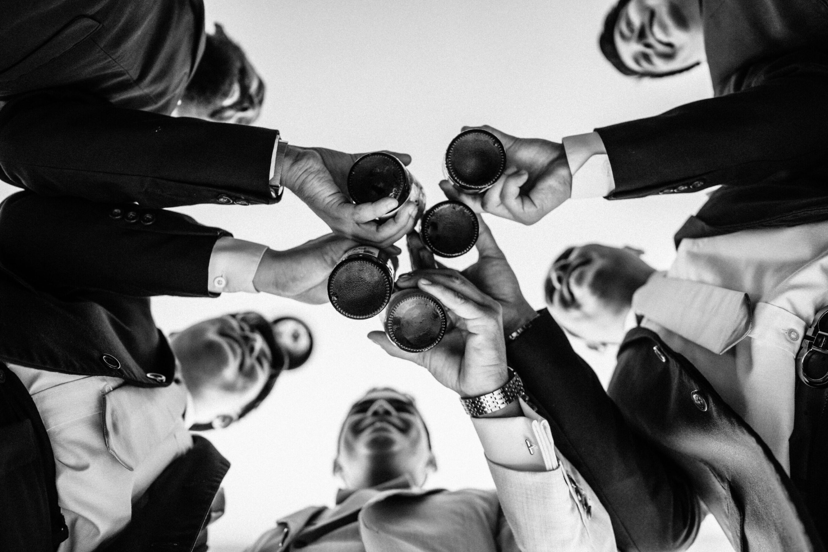 Group of people standing in a circle holding beer and wine glasses, team culture