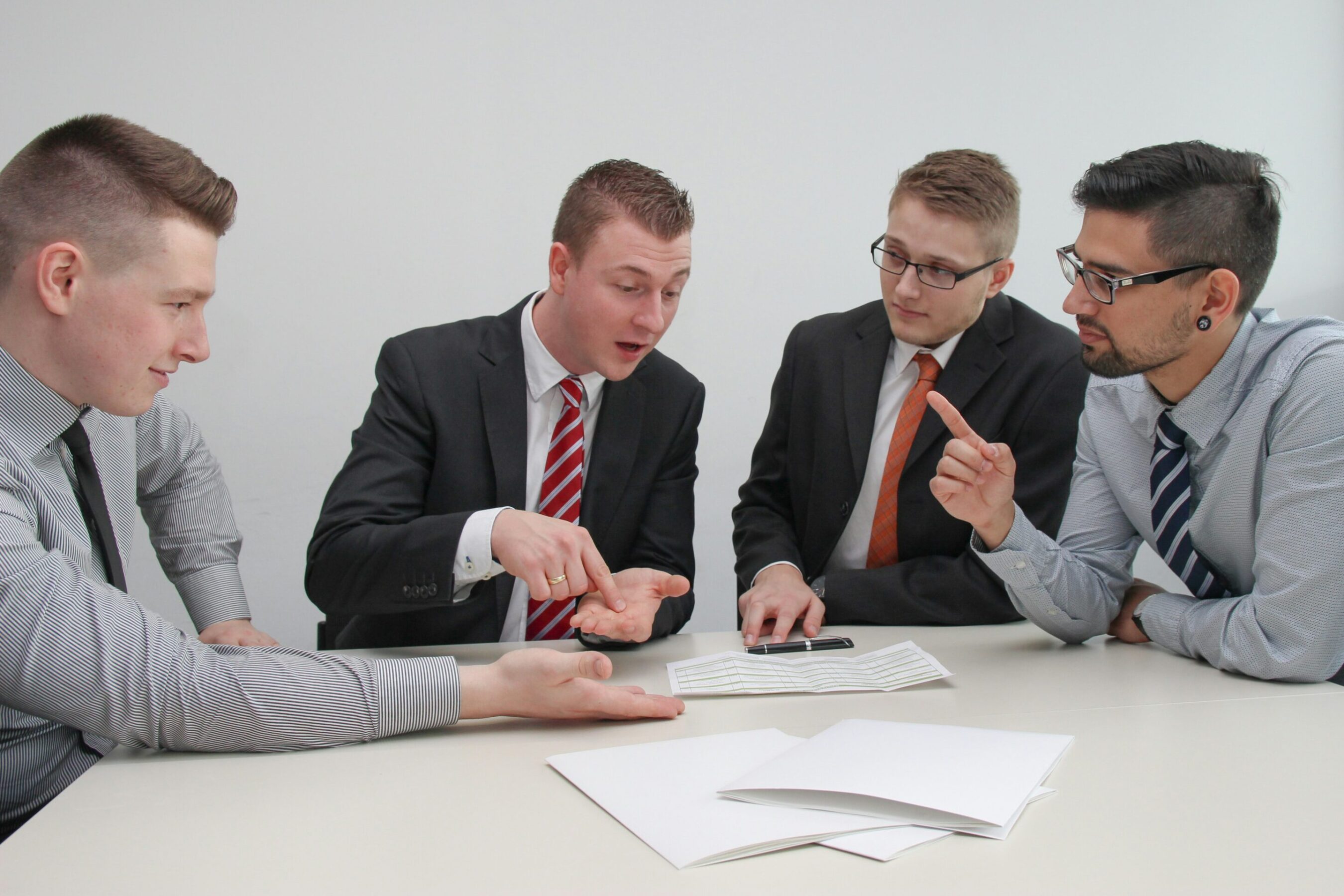 Four men sitting at desk in discussion
